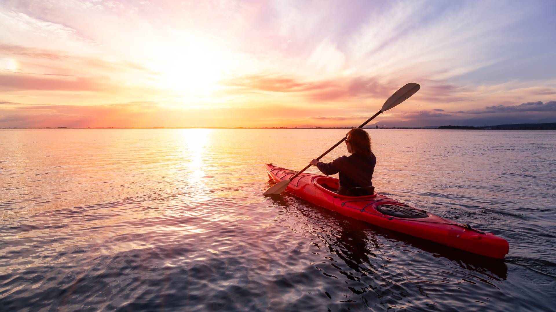 woman kayaking at sunset